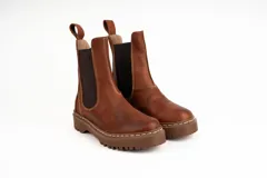 Bota corta marrón de cuero con elástico lateral, suela track y tirador trasero.