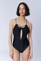 Traje de baño enterizo negro con breteles finos y escote profundo en V con detalle de tiras cruzadas.