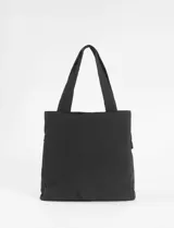 Cartera tipo shopper de gran tamaño en color negro, confeccionada en poliéster. Presenta múltiples bolsillos frontales con cierres metálicos y tiradores de cordón, además de un compartimento principal con cierre. Cuenta con correas anchas para llevar al hombro.