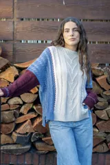 Sweater de punto con diseño de ochos y estilo patchwork, combinando paneles en colores terracota, marrón y beige. Presenta cuello redondo, mangas largas y costuras decorativas a la vista.