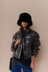 Campera puffer color marrón con cuello alto, cierre frontal con cremallera y bolsillos laterales.