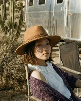 Sombrero marrón de ala ancha con cinta decorativa.