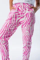Pantalón babucha con estampado de cebra en fucsia y blanco, corte ajustado, cintura elástica y tejido liviano.