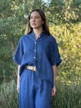 Camisa verde militar de lino italiana con botones de nácar, corte holgado, cuello camisero y mangas cortas con dobladillo.