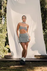 Top strapless de corte ajustado con estampado de cuadros vichy en blanco y negro. Presenta un cierre frontal con gancho metálico y un cuello tipo choker integrado en la misma tela.