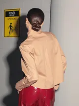 Camisa color camel de poplin de algodón, manga larga y largo a la cintura. Tiene un bolsillo bordado con el isologo de Renée a tono.