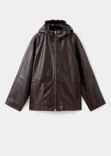 Chaqueta de cuero ovino color marrón oscuro, con diseño oversize, capucha ajustable, cierre frontal con cremallera, bolsillos laterales y bajo con cordón ajustable.