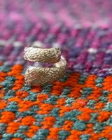 Anillo de diseño abierto con textura escamada que simula la piel de una serpiente, elaborado artesanalmente en metales nobles.
