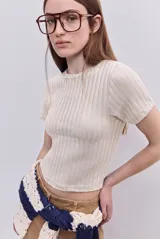 Top de manga corta color beige, confeccionado en tejido elastizado con textura acanalada, cuello redondo y calce al cuerpo.