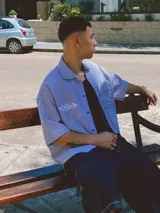 Camisa de manga corta con corte híbrido boxy fit/oversize, confeccionada en algodón. Disponible en tres diseños: a cuadros marrones, a rayas blancas y negras, y a rayas burdeos y blancas. Presenta bordados de diseño propio de la marca.