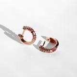 Par de aros tipo argolla de acero con baño de oro rosa de 18k y cristales de colores en el frente.