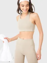 Top deportivo color beige con espalda estilo nadador y almohadillas removibles.