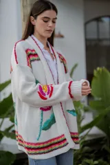 Cárdigan largo de punto color crudo con bordados florales multicolores hechos a mano.