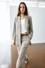 Blazer marrón de cuello solapa con muescas, manga larga y bolsillos de vivo con solapa. Cierre frontal con un botón.