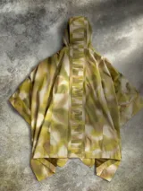 Poncho impermeable de diseño técnico con estampado camuflado en tonos tierra, cuello alto con cierre frontal parcial, capucha integrada y cinturón ajustable con compartimentos. Incluye parches decorativos en el pecho.
