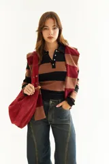 Top de manga larga con diseño de rayas horizontales en tonos negro y marrón, cuello polo con cierre de botones y bordado pequeño en el pecho.