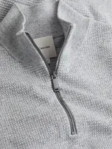 Buzo gris con textura tipo waffle, cuello alto con media cremallera, puños y dobladillo con punto canalé y mini monograma de Calvin Klein bordado.