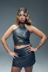 Minifalda gris de símil cuero con apliques de tres tiras con hebillas metálicas y cierre invisible atrás.