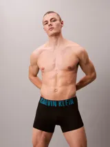 Pack de tres bóxers tipo trunk de Calvin Klein, color negro, con cinturilla elástica distintiva que presenta el logo de la marca en diferentes colores: verde menta, azul y blanco.