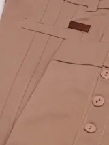 Pantalón de montar negro tableado, de corte ajustado y tiro alto, con detalles de botones en el tobillo.