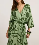 Vestido evasé midi de mangas amplias, confeccionado en viscosa, con escote en V, elástico y lazo en la cintura y estampado de follaje en tonos verdes.