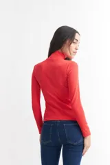 Polera gris de canalé con cuello alto y mangas largas.