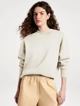 Buzo de cuello redondo en color beige, con diseño liso, mangas largas y puños y ruedo acanalados.