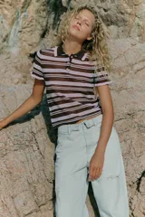 Bermuda tipo jorts de denim en color celeste claro, con tiro medio, diseño de cinco bolsillos y cinturilla doblada. Presenta roturas decorativas en la parte delantera y cierre frontal con cremallera y botón metálico.