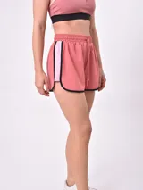 Short deportivo rosado con cintura elástica con cordón de ajuste, ribetes negros y franja lateral en color rosa claro.