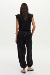 Pantalón estilo babucha de tafeta negra, con cintura elástica y puños ajustables en los tobillos.