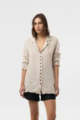 Camisa Riva de lino color beige, de calce relajado y silueta ligeramente oversized, con solapa y cierre frontal de botones.