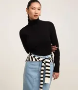 Suéter de punto color negro con cuello alto estructurado y manga larga. Presenta un diseño liso y texturizado, confeccionado en una mezcla de viscosa y poliamida.