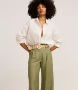 Pantalón wide leg de cintura alta color crudo, confeccionado en viscolino, con trabillas en la cintura, cierre tradicional y pliegues. Incluye cinturón de rafia artificial.