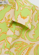 Camisa de manga corta con estampado floral en tonos verde y amarillo. Diseño oversize con cuello camisero y cierre frontal con botones.