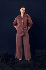 Camisa de gabardina con cuello clásico, cierre frontal de botones y mangas largas con puños vueltos. Presenta un diseño de corte recto y acabado desgastado.