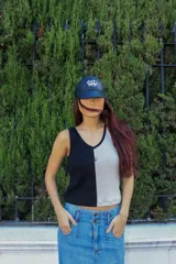 Musculosa con diseño color block, mitad negra y mitad gris claro, con cuello en V y logo bordado en el pecho.