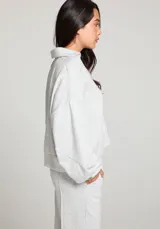 Buzo gris jaspeado de polar, con cuello en V y mangas largas.