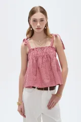 Musculosa de lino con estampado de cuadros vichy en rojo y blanco, escote recto y tirantes anchos con lazos para anudar en los hombros.