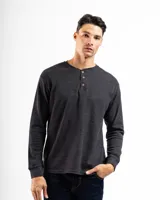 Remera tipo Henley de manga larga confeccionada en tejido de algodón con textura mini piqué. Presenta un cierre frontal de medio cuello con tres botones y puños ajustados en las mangas.