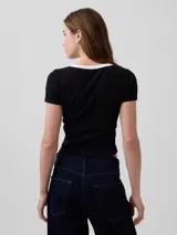 Remera corta de ajuste ceñido color blanco con cuello redondo y ribete negro. Presenta mangas cortas y el logo bordado de Gap en el pecho.