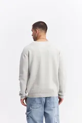 Sweater de algodón de calce relajado, con cuello redondo, mangas largas y puños y ruedo acanalados. Presenta un pequeño logo bordado en el centro del pecho.