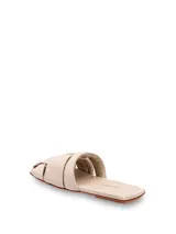 Sandalias mule chatas de cuero color suela, con capellada trenzada y plantilla forrada. Modelo de punta cuadrada.