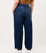 Pantalón wide leg de jean color azul oscuro con diseño de tiro alto, pernera amplia y recta, bolsillos estilo five pockets y cierre frontal con botón y cremallera.