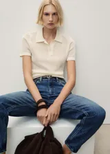 Jeans de tiro alto con corte mom-fit, confeccionados en tejido de algodón estilo vaquero. Presentan cierre de cremallera con botón, trabillas para cinturón y diseño clásico de cinco bolsillos.