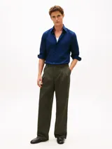 Camisa azul marino de manga larga confeccionada en tejido twill, con cuello flexible y cierre frontal de botones.