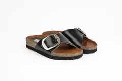 Sandalias marrones de cuero con suela tipo corcho y una tira ancha en el empeine con hebilla metálica grande.