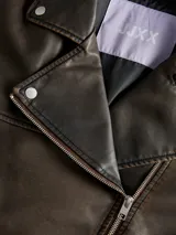 Campera estilo biker de efecto cuero en color marrón desgastado, con cuello solapa, cierre frontal asimétrico, bolsillos laterales con cierre y bolsillo pequeño con solapa y botón a presión. Presenta un corte holgado y diseño versátil.