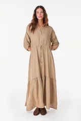 Vestido camisero largo de lino italiano color celeste, de corte relajado, con mangas caídas, jareta ajustable en la cintura, cierre frontal de botones y bajo con volado fruncido.