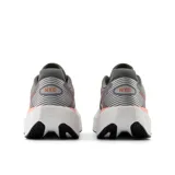 Championes de running New Balance FuelCell Rebel v5, color gris con detalles en naranja y suela blanca.