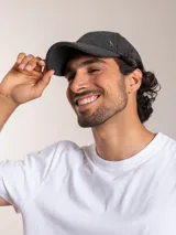 Gorro con visera color verde oscuro, de lana y poliéster, con logo de pájaro bordado en plateado en el frente.